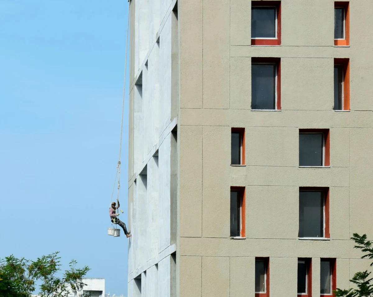 Schilder aan het werk aan de gevel van een woning